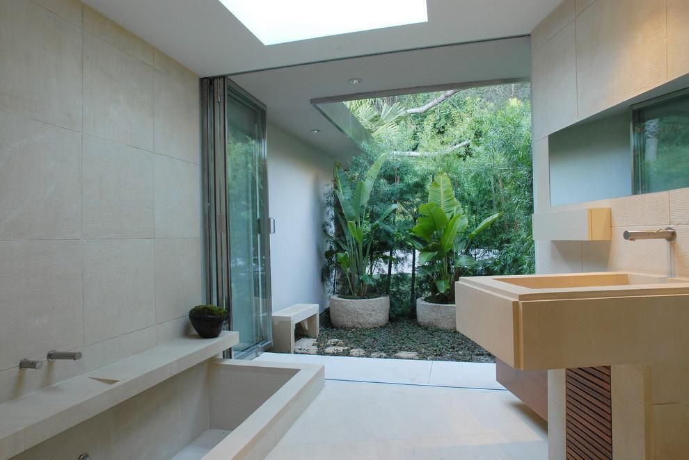 La salle de bain s'ouvre par des portes vitrées avec un beau jardin en arrière-plan.