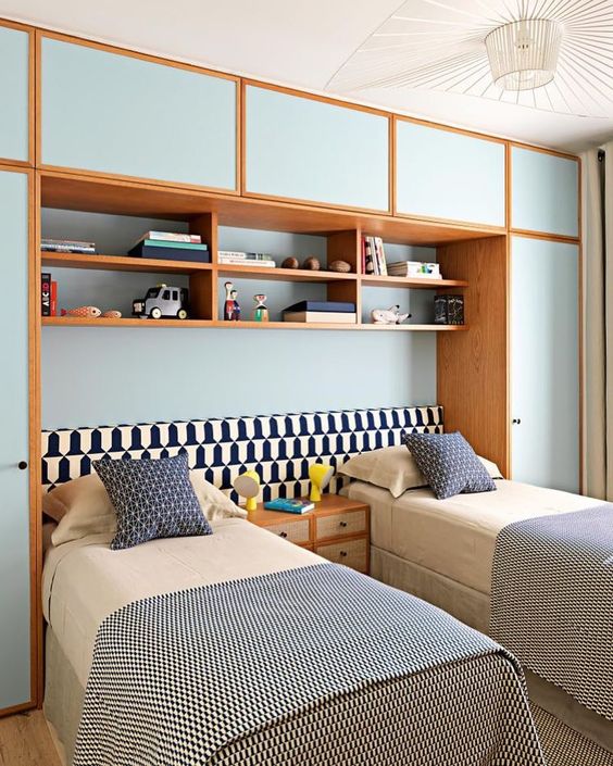 La chambre double est décorée avec des armoires bleues personnalisées.