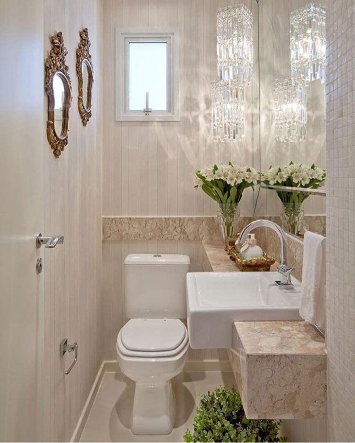 Décoration de petit appartement, salle de bain avec lustre en cristal, miroir et fleurs fraîches.