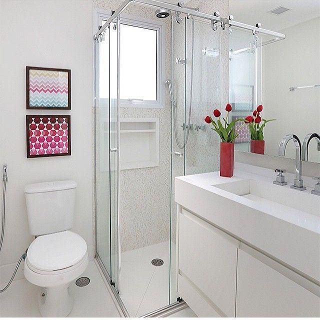 La petite salle de bain est décorée de tableaux colorés et de vases dans le lavabo.