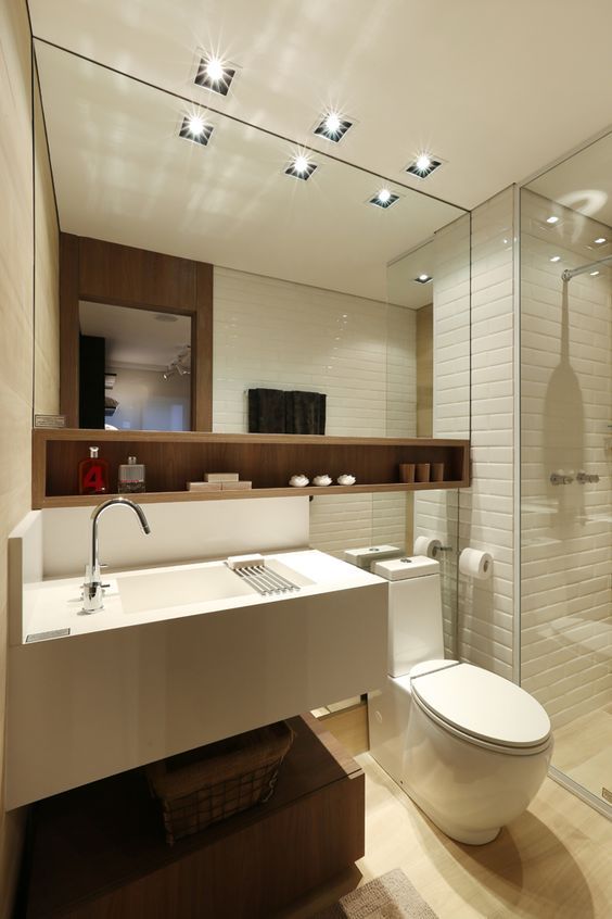 Petit décor d'appartement, salle de bain avec grand miroir et meuble de rangement en bois. 