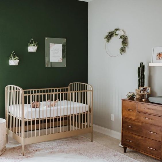 Chambre bébé berceau naturel et murs vert foncé