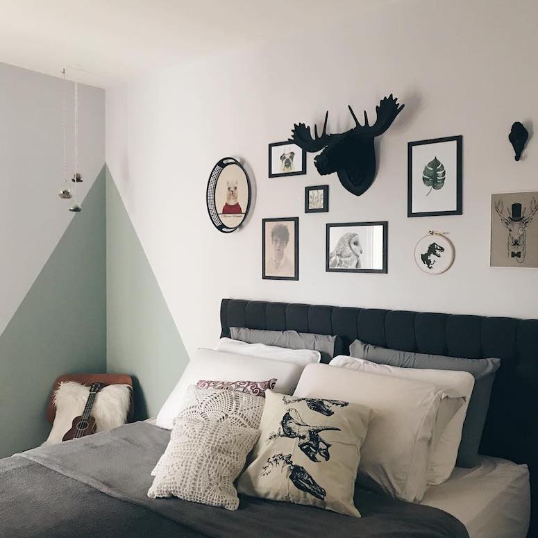 Chambre double avec graphisme mural et tête de lit noire. 