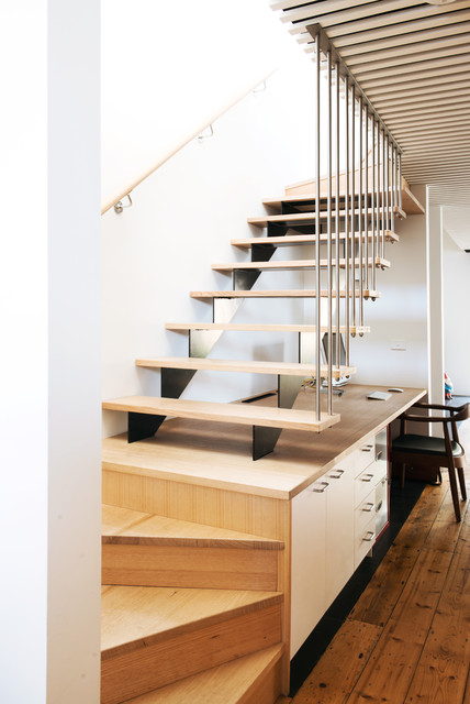 Escaliers en bois avec garde-corps verticaux.