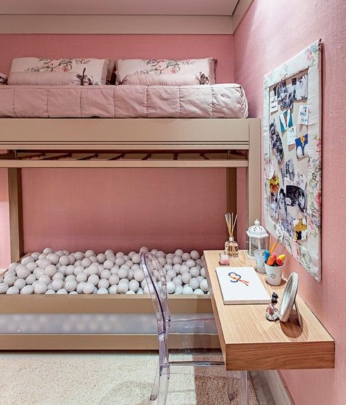 Chambre d'enfant rose avec piscine à balles et table d'étude