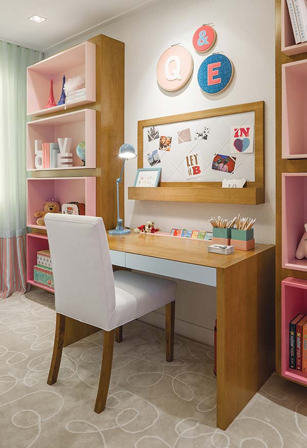 Chambre de fille décorée d'une table et d'étagères roses