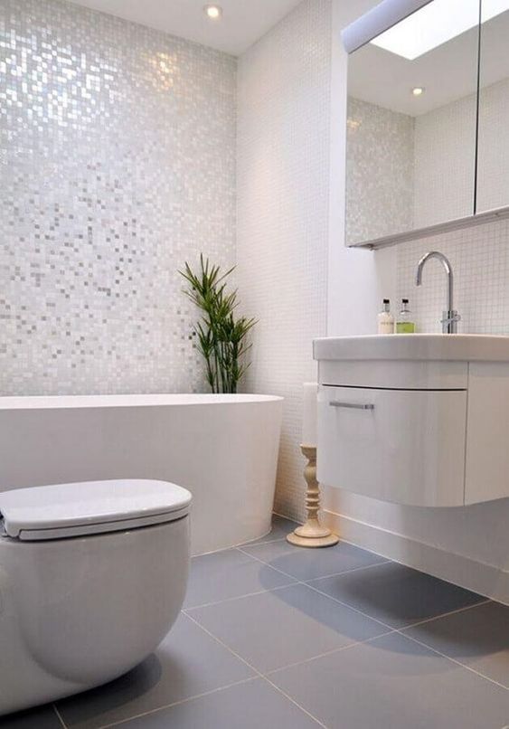 Salle de bain toute blanche avec carrelage blanc et gris.
