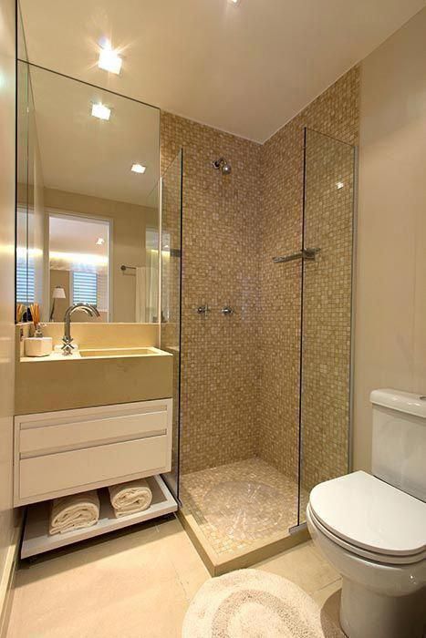 Petite salle de bain dans les tons crème avec des incrustations dorées.