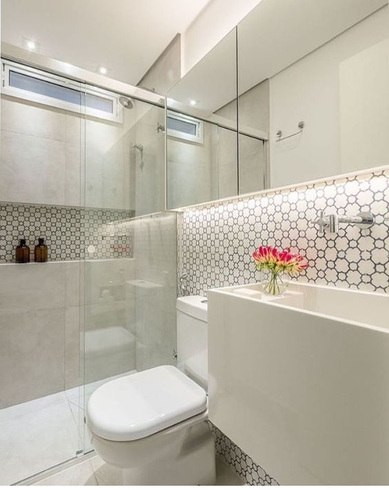 Miroir rectangulaire à deux portes dans la salle de bain blanche. Bande avec tablette et bol entier du bas jusqu'à la hauteur du robinet. 