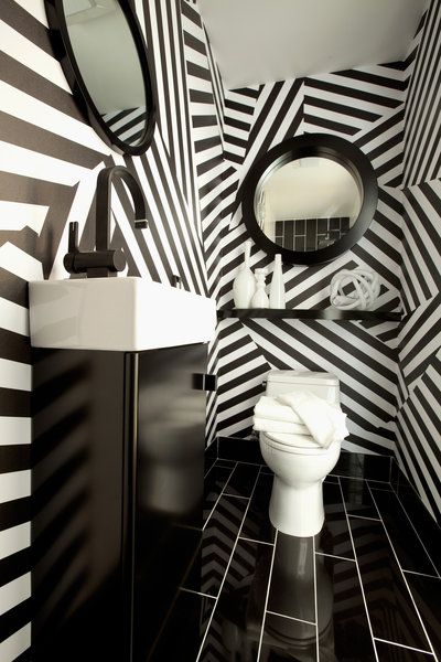 Lavabo en noir et blanc avec deux miroirs ronds.