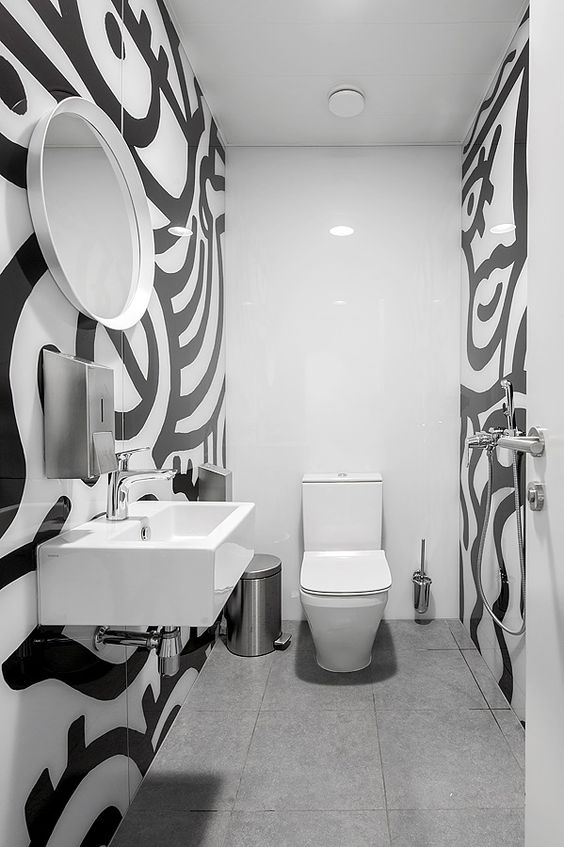 Salle de bain blanche avec un design noir sur les parois latérales.