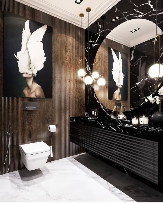 Le mur du lavabo et du miroir dans la grande salle de bain est composé de pierres noires et blanches mélangées.