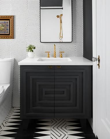 Les murs et les sols de la salle de bain ont des revêtements différents, des motifs en noir et blanc.