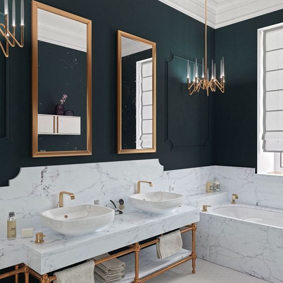 Les salles de bains en noir et blanc présentent des accents dorés sur les miroirs, les lustres, les robinets et les supports d'évier.