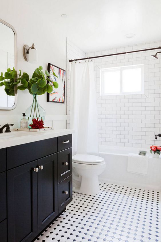 Salle de bain blanche avec armoires noires et planchers mixtes.