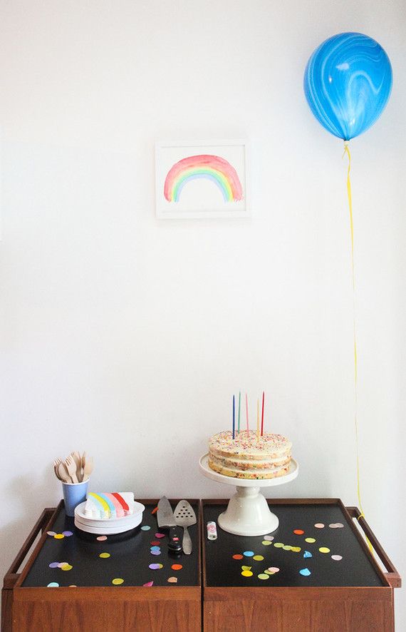 Ballons, cupcakes et quelques confettis sur la table d'anniversaire de bébé