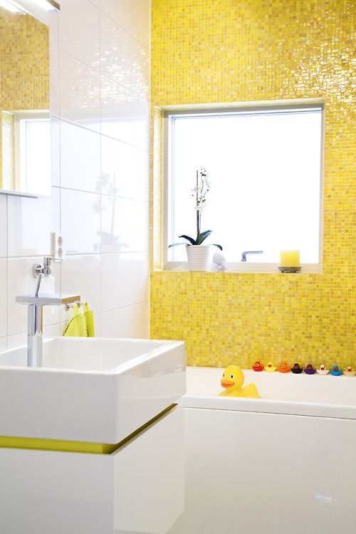 Baignoire de salle de bain et mur plat jaune avec jouets.