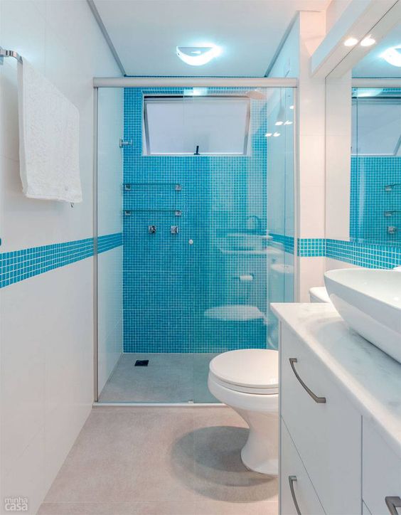La salle de bain toute blanche a des murs bleus ébréchés.