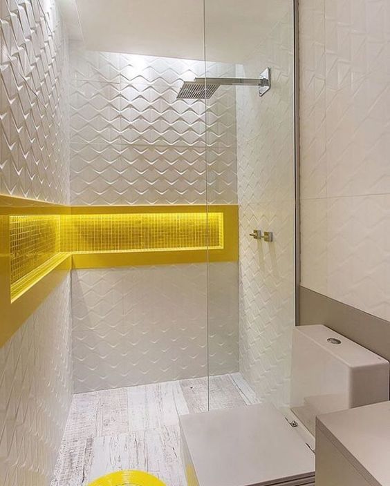 La salle de bain est agrémentée d'alcôves et d'inserts jaunes.