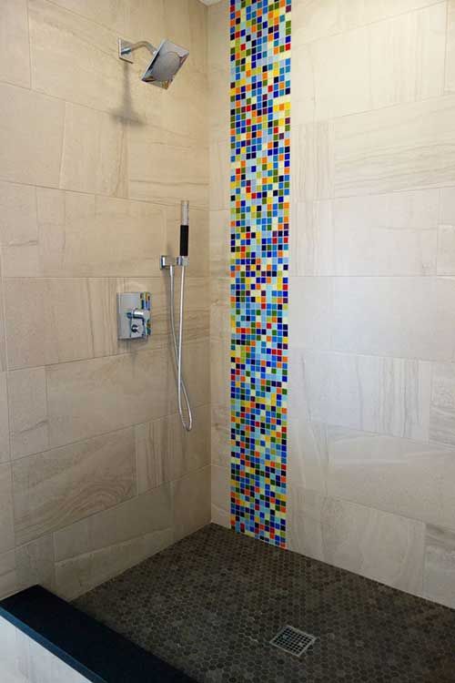 La salle de bain a un sol carrelé marron et une bande verticale de couleur sur l'un des murs.
