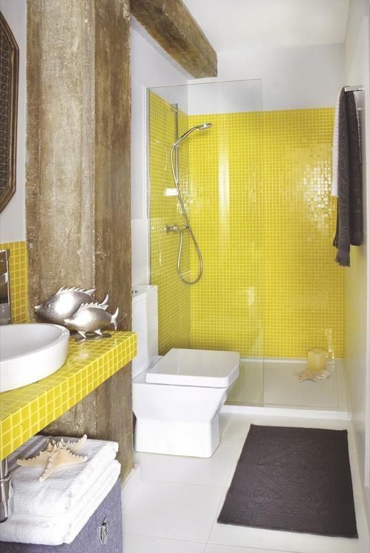 La salle de bain est décorée de poissons, d'étoiles de mer et d'inserts jaunes.
