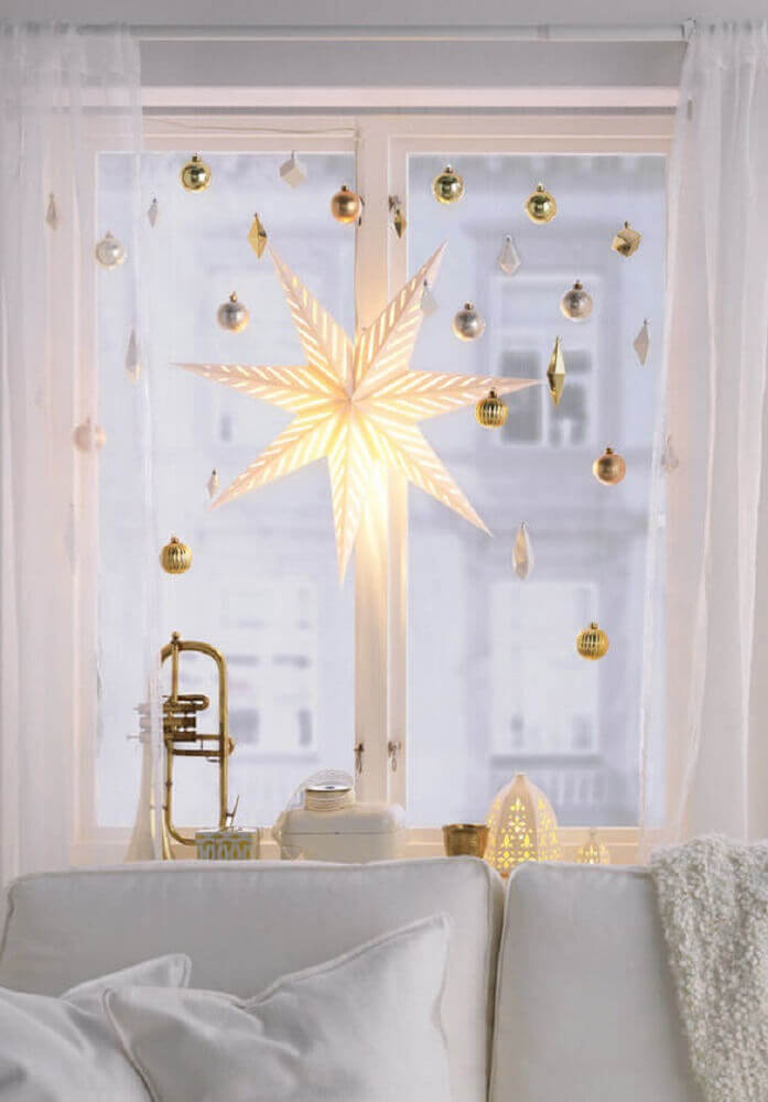 Décoration de Noël de petite chambre avec des lumières étoiles et des boules de Noël dorées.