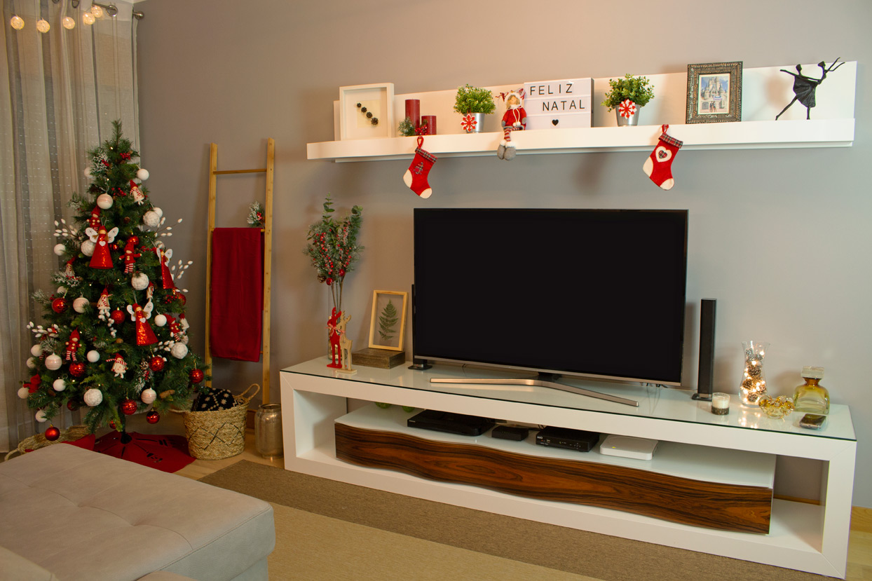 Décoration de Noël pour petite pièce, arbre de Noël décoré, chaussettes, bougies et tapis rouge.