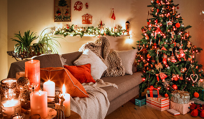 Décoration de Noël dans une petite chambre de luxe avec sapin de Noël, bougies et décorations.