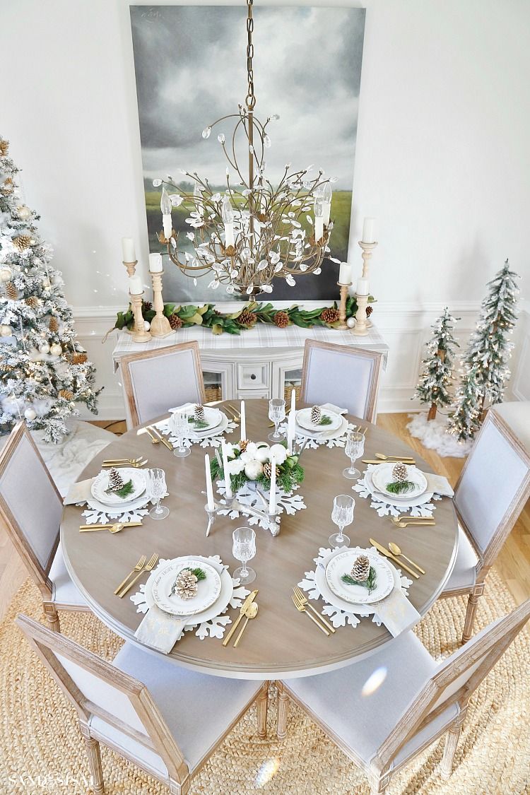 Décoration de Noël au restaurant avec arbres décoratifs, couverts dorés et sets de table à thème.