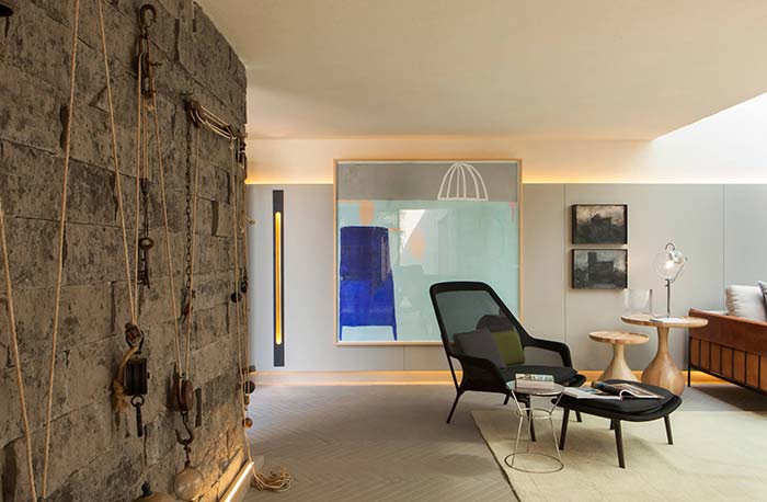 Des murs rugueux et rustiques aux accents inhabituels contrastent avec la chambre propre et meublée avec douceur.