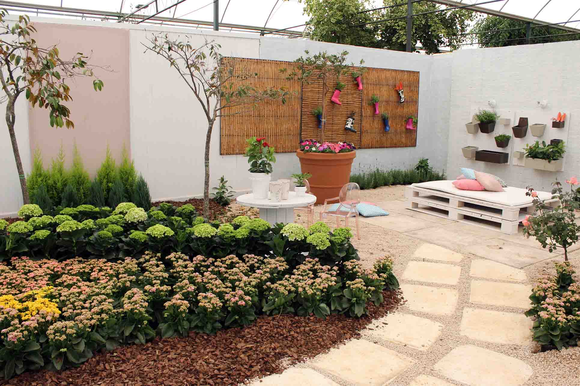 Un jardin décoré avec des matériaux recyclés et des palettes.