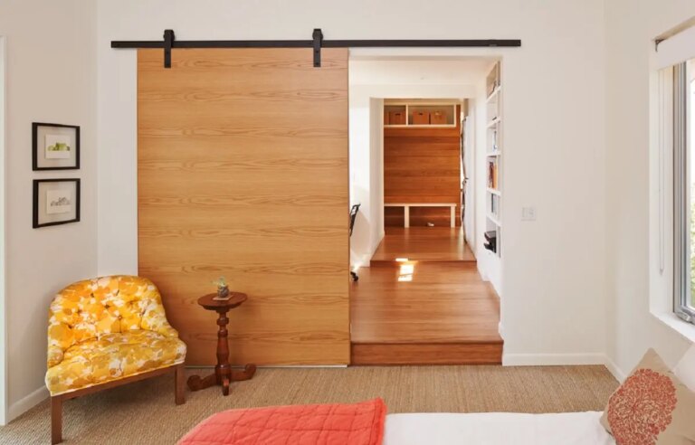 A porta de correr branca para quarto é discreta e se encaixa perfeitamente nesse dormitório pequeno