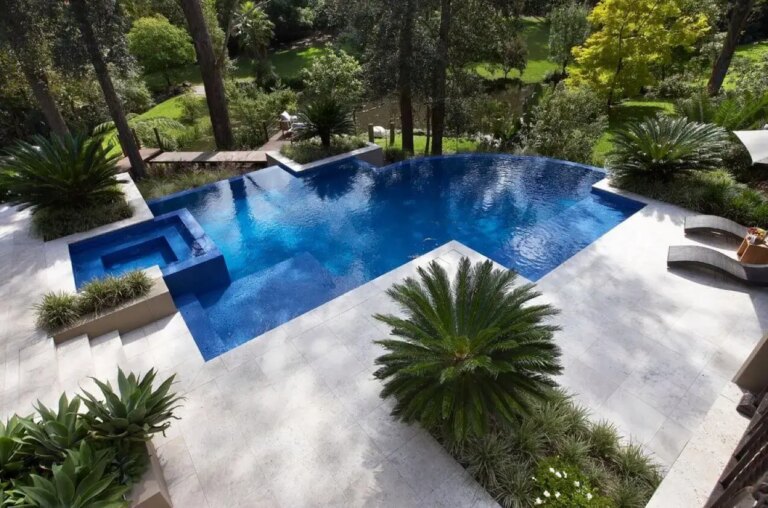 Ambiente externo com piso branco e piscina com borda infinita