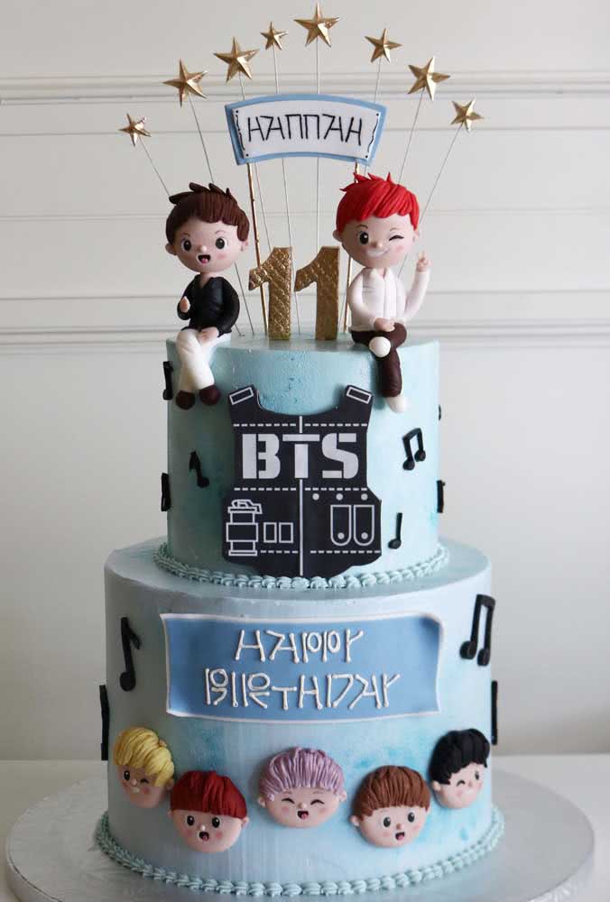 Ici, le gâteau BTS est décoré de fondant, avec deux étages et des poupées biscuits pour représenter les garçons du groupe.