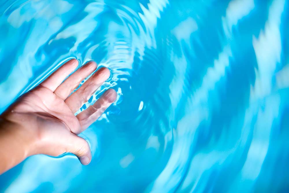 Comment nettoyer une piscine : les mains dans l'eau