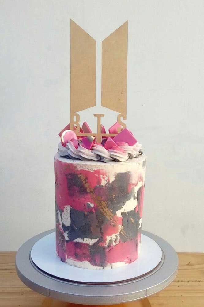 Un gâteau BTS coloré avec un chapeau haut de forme qui apporte la marque du groupe d'adolescents